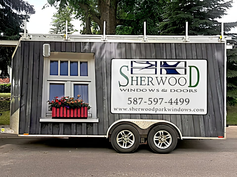 Sherwood Windows display trailer with a window, flower box, and company sign.